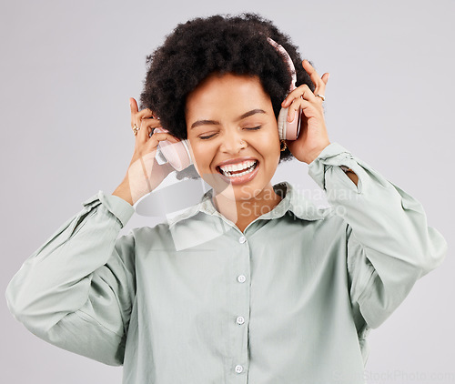 Image of Music headphones, black woman and singing in studio isolated on a white background. Singer, radio and happiness of person listening, streaming or enjoying audio track, sound album or podcast song.