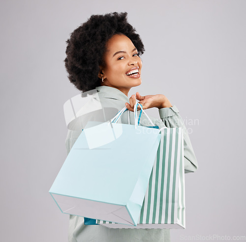 Image of Portrait, shopping bags and black woman laughing in studio isolated on a white background. Sales deals, fashion and happiness of person or customer with products after buying at mall, store or shop.