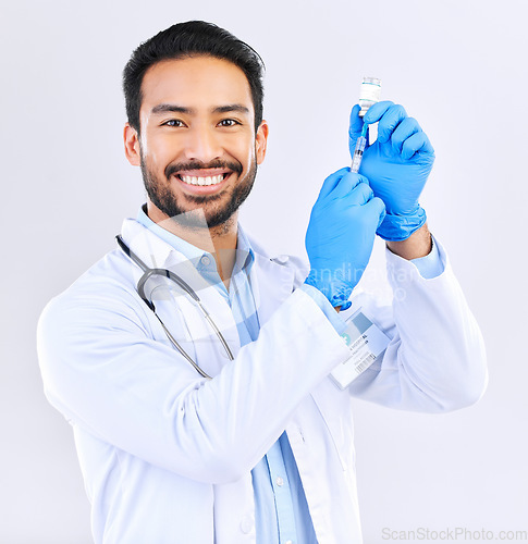 Image of Portrait of doctor with smile, syringe and vaccine in studio for healthcare, medicine and innovation in medical science. Vaccination, booster shot and Indian man, virus protection on white background