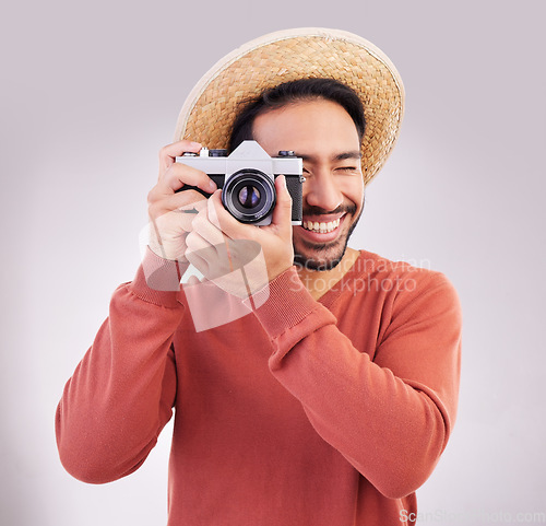 Image of Travel, camera and happy man on holiday, adventure and fun on white background. Smile, travel and person taking picture, photographer or tourist in studio for summer vacation, journey and happiness.