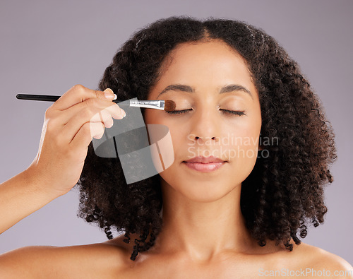 Image of Woman, makeup and eyeshadow brush in studio for cosmetics, facial skincare and salon transformation. Female model, beauty and application on eyes for aesthetics, cosmetology or facelift on background