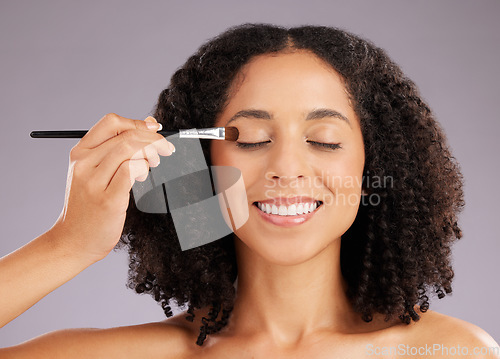 Image of Woman, beauty and eyeshadow brush in studio for cosmetics, facial skincare and salon transformation. Happy female model makeup application on eyes for aesthetics, happiness and facelift on background