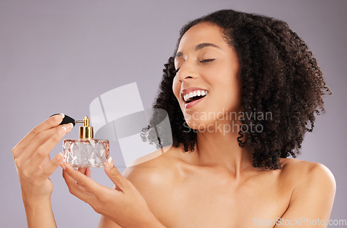 Image of Beauty, luxury and female in a studio with perfume for a fresh scent, bodycare or wellness. Happy, smile and woman model with bottle of fragrance for cosmetic health isolated by a gray background.