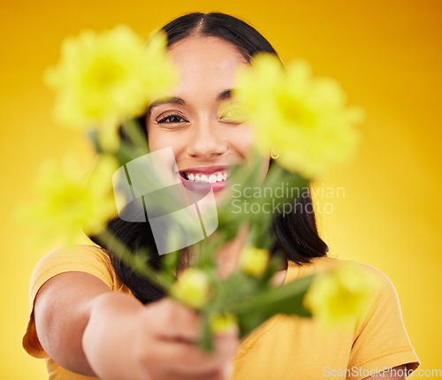 Image of Happy, portrait and a woman showing flowers isolated on a yellow background in a studio. Floral, spring and a girl giving a bouquet as a present, sharing plants and fresh flower with a smile