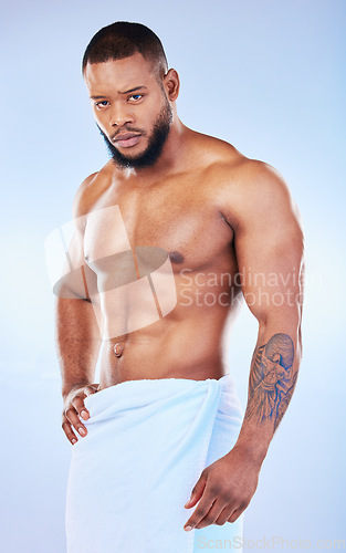 Image of Portrait, skincare and body with a man on white background and wearing a towel in studio after cleaning. Hygiene, grooming and serious muscular african male model posing shirtless in his bathroom