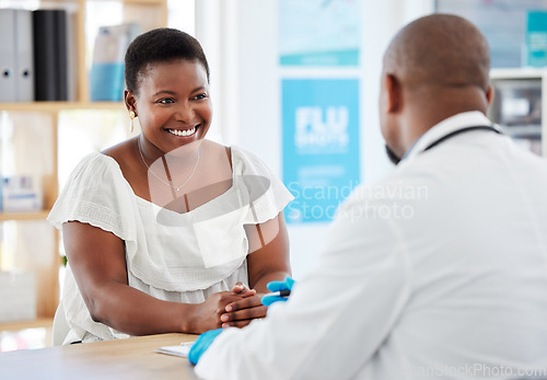 Image of Doctor, black woman and healthcare consultation with a wellness and hospital worker in office. Consulting, patient and happy female with smile from health communication and expert advice in a clinic