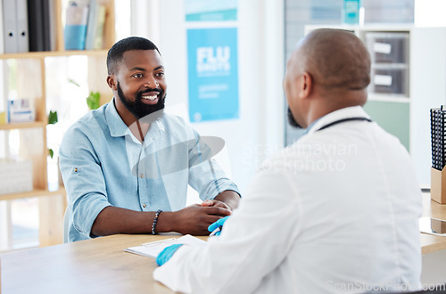 Image of Doctor, black man and healthcare consultation with a wellness and hospital worker in a office. Consulting, patient and happy male with a smile from health communication and expert advice in a clinic