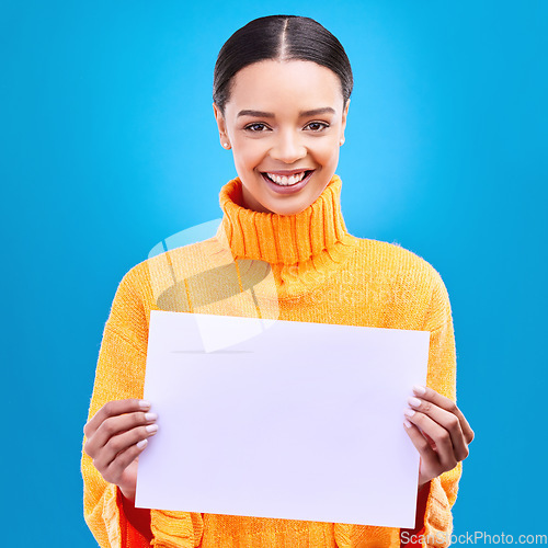 Image of Happy, mockup and paper with portrait of woman in studio for idea, branding and announcement. Promotion, space and smile with female and sign on blue background for news, logo and advertising