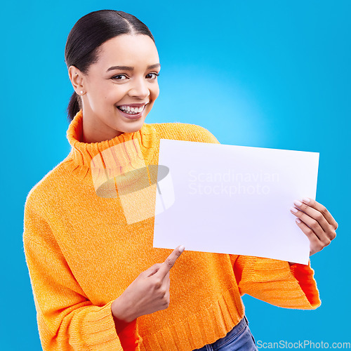 Image of Pointing, mockup and poster with portrait of woman in studio for idea, branding and announcement. Promotion, space and smile with female and sign on blue background for news, logo and advertising