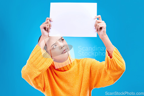 Image of Paper, banner and confused woman in studio on blue background with space, mockup and poster. Billboard, poster and unsure girl showing blank copy space, branding or isolated logo announcement