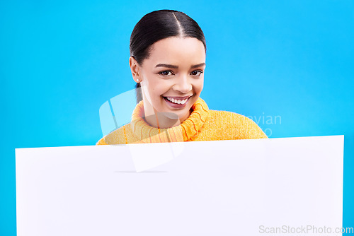 Image of Happy, mockup and poster with portrait of woman in studio for idea, branding and announcement. Promotion, space and smile with female and sign on blue background for news, logo and advertising
