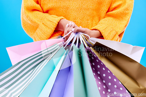 Image of Shopping bags, studio and woman hands with deal and gifts from boutique sale. Retail, customer and female model with store bag and sales choice in isolated blue background with fashion purchase