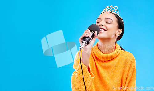 Image of Singer woman, crown and microphone in studio mockup with smile for singing performance by blue background. Happy gen z girl, model or recording artist mic for karaoke, music and mock up with tiara