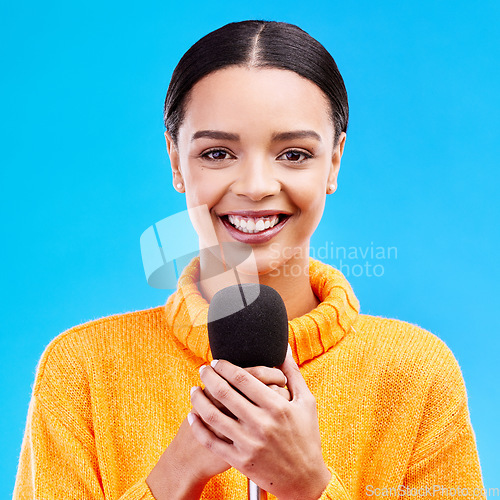 Image of Happy, microphone and portrait of woman in studio for singing, karaoke and journalist. Reporter, news announcement and media with female on blue background for information, interview or communication