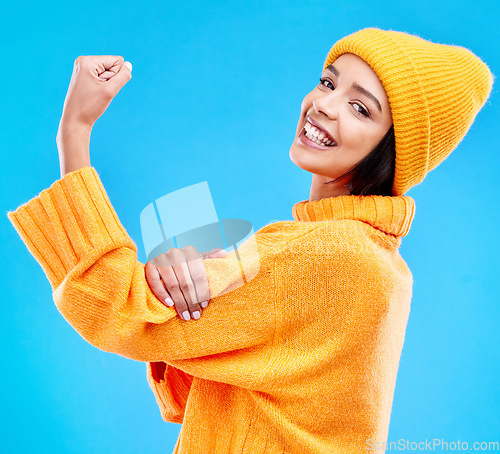 Image of Happy, arm and portrait of a woman with muscle isolated on a blue background in a studio. Smile, strong and a girl showing muscles, power and motivation for exercise on a backdrop for confidence