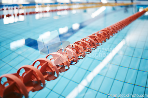 Image of Water, empty swimming pool and lanes for competition, exercise and workout. Sports, swim and fitness with lane ropes or divider in liquid for aquatic training, exercising or underwater practice.