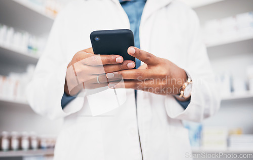 Image of Hands, phone and healthcare with a pharmacist woman at work in a drugstore or dispensary for communication. Pharmacy, mobile and contact with a female medicine professional working in an apothecary