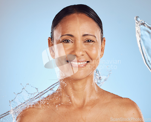 Image of Old woman, face with water splash and beauty in portrait, hygiene and sustainable skincare for antiaging on blue background. Clean, female smile and eco friendly dermatology, cosmetic care in studio