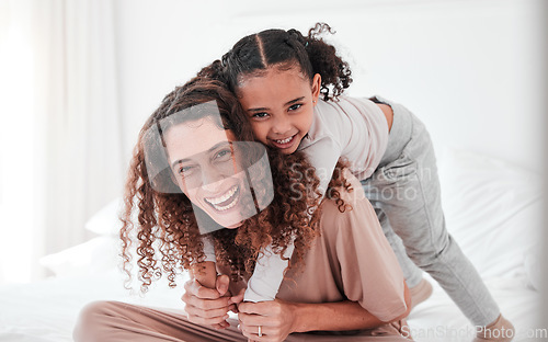 Image of Portrait, mother and girl on bed, piggy back and smile with joy, bonding and quality time. Face, mama carry daughter or happiness in bedroom, loving or interracial with female child, kid or mom relax