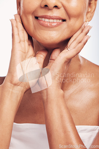 Image of Hands, mouth and skin with a mature woman in studio for beauty, anti aging treatment or cosmetics. Skincare, facial and wellness with a senior female moisturizing her face for hydration closeup