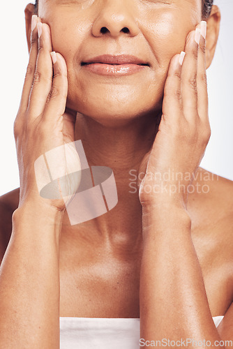 Image of Hands, mouth and skincare with a senior woman in studio for beauty, anti aging treatment or cosmetics. Skin, facial and wellness with a mature female rubbing her soft face for hydration closeup