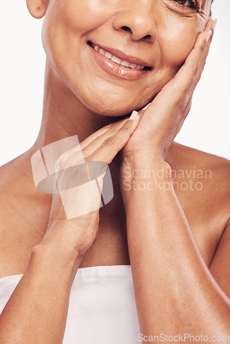 Image of Hands, mouth and beauty with a senior woman in studio for skincare, anti aging treatment or cosmetics. Skin, facial and wellness with a mature female touching her soft face for hydration closeup