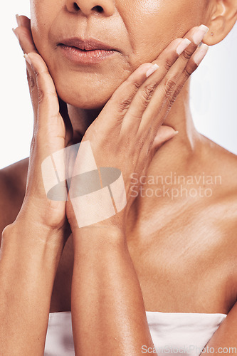 Image of Hands, mouth and beauty with a mature woman in studio for skincare, anti aging treatment or cosmetics. Skin, facial and wellness with a senior female touching her face for hydration closeup