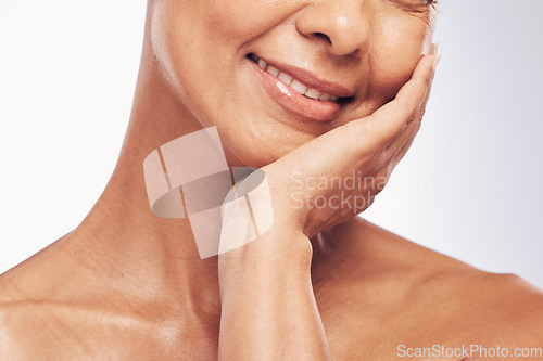 Image of Hand, mouth and skincare with a mature woman in studio for beauty, anti aging treatment or cosmetics. Skin, facial and wellness with a senior female touch her face for happy self care closeup