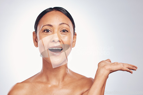Image of Wow, skincare and portrait of a woman with space for product placement isolated on a studio background. Advertising, shock and a mature model showing mockup for branding, beauty and cosmetics