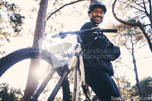 Image of Forest, fitness and portrait of cyclist with bicycle in nature with smile, adventure trail and health from below. Cycling, woods and man with mountain bike in trees for workout, motivation or energy.