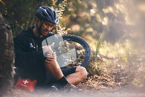 Image of Man, cycling and outdoor with leg or knee injury in nature for sports, exercise or training on mountain bike. Athlete person with bicycle and first aid for fitness workout accident or fall in forest