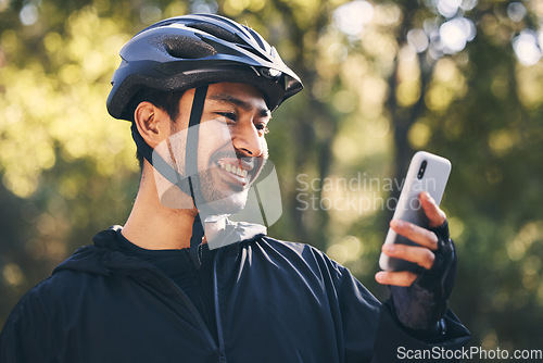 Image of Man, cycling and outdoor with a phone for communication in nature for sports, exercise or training app. Athlete male person with helmet and smile for fitness workout with smartphone for travel or gps