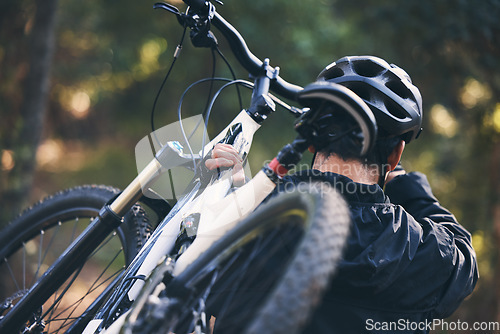 Image of Forest, fitness and man carrying bicycle in nature with helmet, exercise adventure trail and healthy mindset. Cycling, woods and cyclist with mountain bike in trees for workout, motivation or energy.