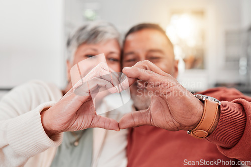 Image of Couple, senior and heart hands in home, love and bonding in retirement together. Romance, hand gesture and elderly man and woman with emoji for care, affection and empathy, commitment and trust.