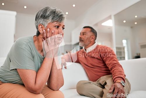 Image of Divorce, stress and senior couple in home living room on sofa with conflict, infidelity or cheating. Retirement, elderly and man and woman fighting, sad or depressed with marriage problem or thinking