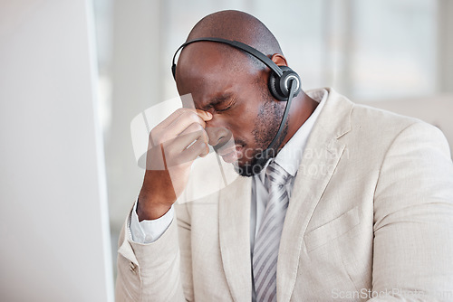 Image of Tired call center man with headache, fatigue and pain on computer customer support, telecom working or virtual help desk. Burnout agent, stress consultant or african person with migraine at office