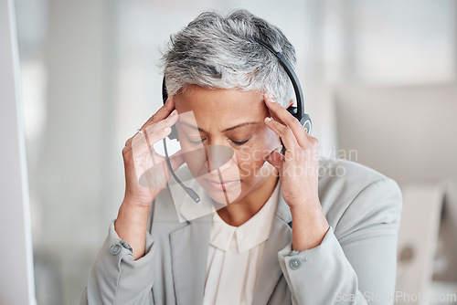 Image of Callcenter consultant, woman with headache, stress and fatigue with CRM and contact us. Senior female, burnout and crisis with customer support or telemarketing, agent with migraine and help desk