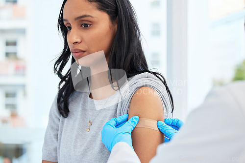 Image of Scared woman, arm and covid with a plaster and doctor for healthcare and medical injection on arm. Female patient at a clinic or hospital for a vaccine with a bandage for virus, health and wellness