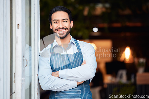 Image of Asian man, portrait smile and arms crossed in small business at restaurant for welcome, service or job at door. Happy male entrepreneur in confidence at entrance ready to serve in coffee shop or cafe