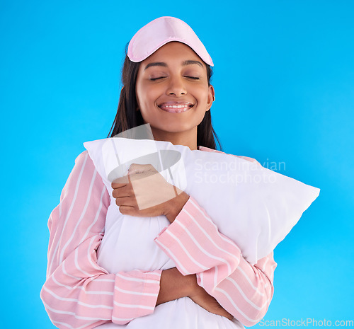 Image of Sleep, happy and a woman hugging a pillow isolated on a blue background in a studio. Smile, comfy and a girl ready for sleeping, nap or slumber in pyjamas for comfort and coziness on a backdrop