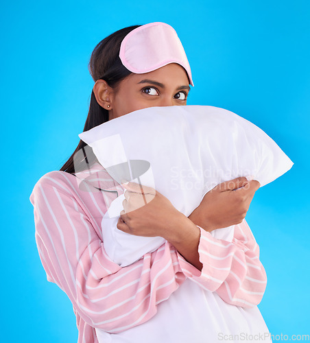 Image of Comfy, bedtime and a woman hugging a pillow isolated on a blue background in a studio. Relax, rest and an Indian girl ready for sleep, napping or night rest and thinking of sleeping on a backdrop