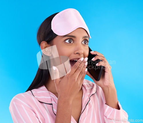 Image of Phone call, surprise and female in pyjamas in studio with shocking, winning or good news. Communication, shock and woman model having gossip conversation with wtf, omg or wow face by blue background.