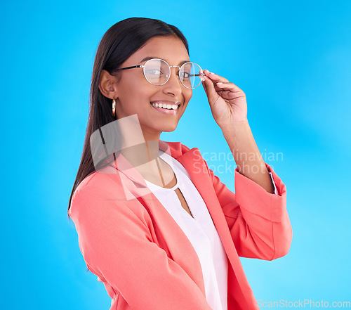 Image of Woman, glasses and happy portrait in studio with a smile for eye care and vision with frame or lens. Smile of Indian female model person on a blue background with specs for fashion and business