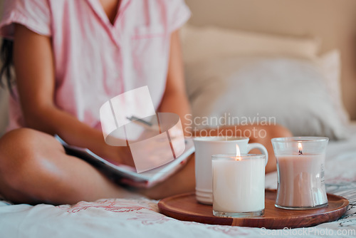 Image of Notebook, writing and woman with home candles for healing journal, calm planning or self care inspiration in bedroom. Creative person or writer for mindfulness goals, meditation or peace notes in bed
