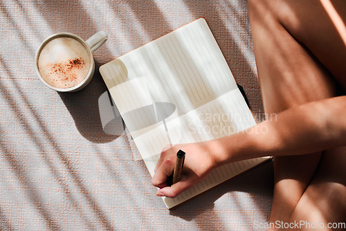 Image of Notebook, writing and woman hands with coffee for ideas, inspiration and creativity on floor above in sunshine. Creative person with latte for mindfulness, healing notes or self care goals of writer