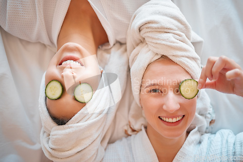 Image of Friends, face and teenager, girl and facial, pampering and beauty, cucumber in portrait for skincare treatment. Happiness, people have fun together and female friendship, cosmetic care and top view