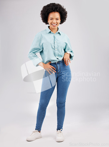 Image of Fashion, casual and young black woman in a studio with a stylish and trendy outfit with a jeans and shirt. Happy, smile and portrait of an African female model with style isolated by gray background.