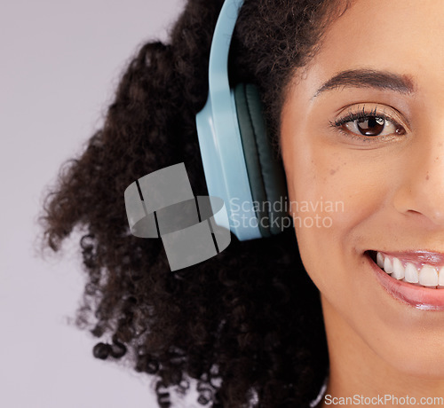 Image of Headphones, happy woman and portrait of half face, studio background and backdrop. Closeup female model, smile and listening to music, sound and streaming media for audio connection, podcast or radio