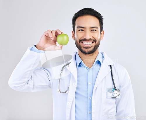 Image of Doctor, man and apple in portrait with smile, health and nutritionist isolated on studio background. Medical professional, happy male physician and healthcare, promote healthy diet and nutrition