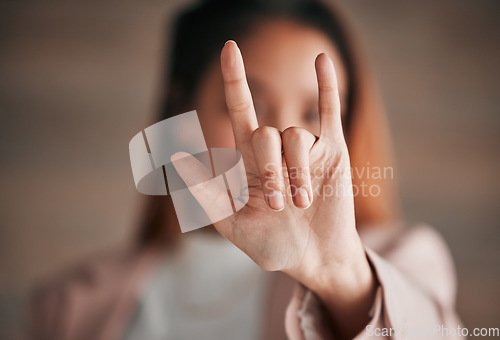 Image of Hand, sign language and love with a person closeup in studio on a blurred background for communication. Emoji, icon or affection and an adult indoor to gesture romance with a fingers icon signal